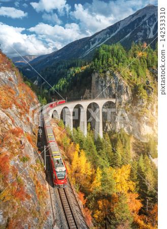 Aerial view of modern red train on Landwasser viaduct Aerial view of modern red train on Landwasser viaduct 142533310