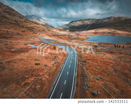 Aerial drone view of wet winding road in the Swiss Alps Aerial drone view of wet winding road in the Swiss Alps 142533311