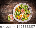 Tuna salad with tomatoes , olives , eggs and onion . 142533357