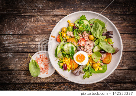 Tuna salad with tomatoes , olives , eggs and onion . 142533357