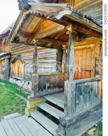 A wooden porch with a wooden door A wooden porch with a wooden door 142533950