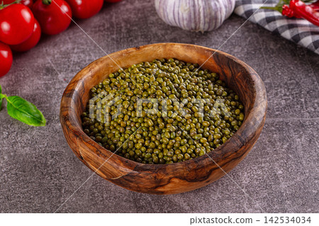 Green mung beans in rustic wooden bowl with cherry tomatoes and garlic Green mung beans in rustic wooden bowl with cherry tomatoes and garlic 142534034