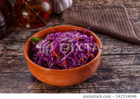 Shredded red cabbage salad in terracotta bowl on rustic wood table Shredded red cabbage salad in terracotta bowl on rustic wood table 142534046