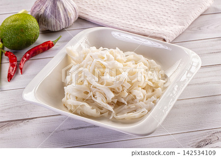 White rice noodles in square bowl with lime garlic and red chili on wooden table White rice noodles in square bowl with lime garlic and red chili on wooden table 142534109