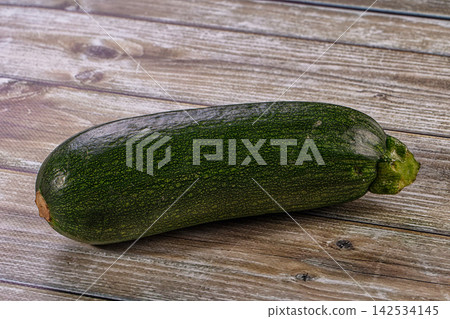 Fresh green zucchini on a rustic wooden table background Fresh green zucchini on a rustic wooden table background 142534145