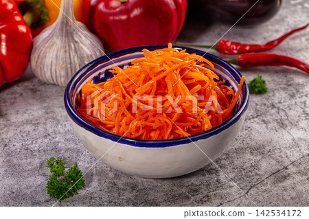 Shredded carrot salad in ceramic bowl with bell peppers and garlic on stone surface Shredded carrot salad in ceramic bowl with bell peppers and garlic on stone surface 142534172
