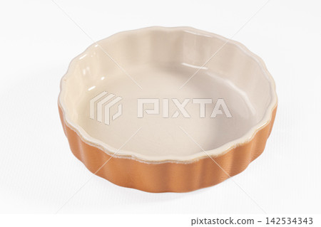 Empty ceramic tart pan with fluted edges on white background 142534343