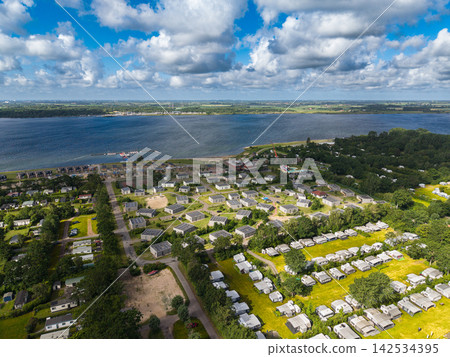 High angle wide horizontal aerial drone photograph of holiday park, modern solar roof chalets, campsite, and Lake Veere near Ruiterplaat, Kamperland, Zeeland, Netherlands on sunny summer day High angle wide horizontal aerial drone photograph of holiday park, modern solar roof chalets, campsite, and Lake Veere near Ruiterplaat, Kamperland, Zeeland, Netherlands on sunny summer day 142534395