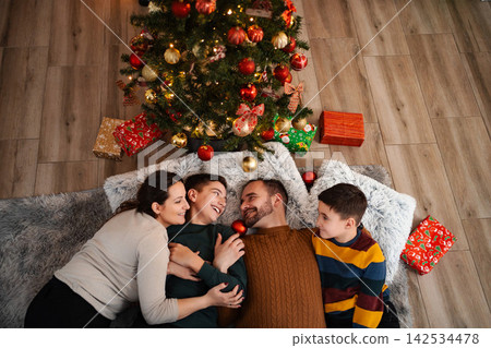 Family enjoying Christmas holiday together near decorated tree Family enjoying Christmas holiday together near decorated tree 142534478