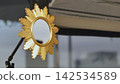 Golden sunburst mirror reflecting room details and studio equipment 142534589