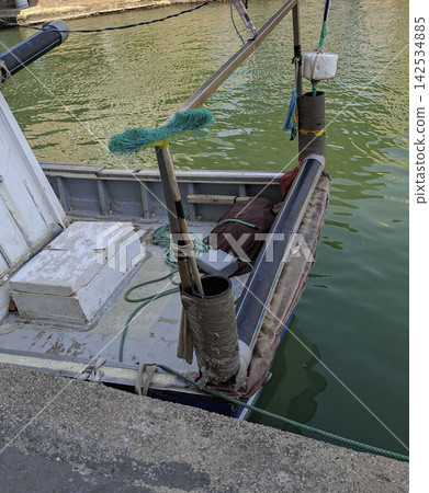 Stern of a small fishing vessel with cleaning broom tied to railing at harbor Stern of a small fishing vessel with cleaning broom tied to railing at harbor 142534885