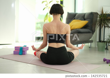 Fit woman wears bandeau top and comfortable black sports shorts 142535721