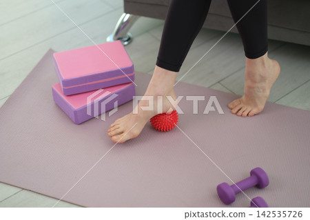 Woman in black leggings performs myofascial release exercise Woman in black leggings performs myofascial release exercise 142535726