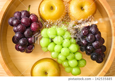 Wash the grapes and pears in a tub. Wash the grapes and pears in a tub. 142535885