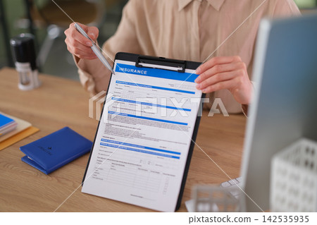 Knowledgeable insurance specialist shows insurance application Knowledgeable insurance specialist shows insurance application 142535935