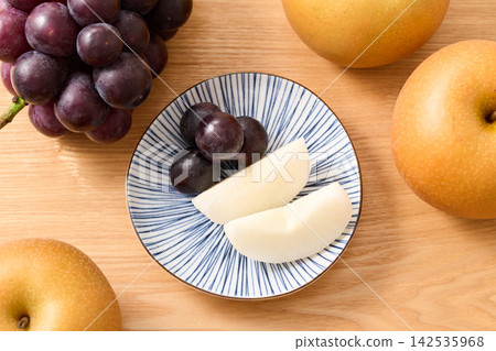 盤子上擺放著葡萄和梨(巨峰梨和秋月梨)。 盤子上擺放著葡萄和梨(巨峰梨和秋月梨)。 142535968
