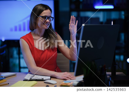 Woman manager waves hand Hello to camera during online meeting Woman manager waves hand Hello to camera during online meeting 142535983