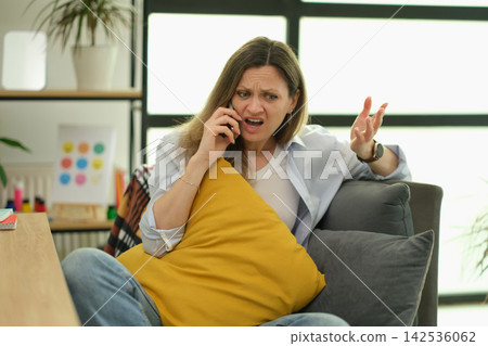 Upset businesswoman argues on smartphone during tense office call Upset businesswoman argues on smartphone during tense office call 142536062