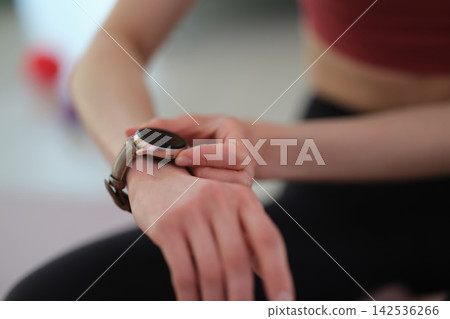 Sportswoman checks fitness tracker to monitor heartbeat in gym Sportswoman checks fitness tracker to monitor heartbeat in gym 142536266