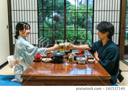 一對身穿浴衣的情侶在溫泉旅館舉杯暢飲啤酒。這是一趟兩人享受懷石料理的旅行。 142537140