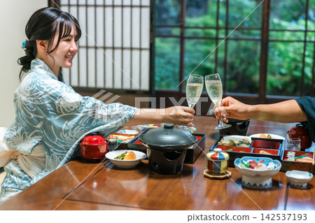 A couple in yukata toasts with champagne at a hot spring inn. They are enjoying a celebratory trip and the inn's cuisine. A couple in yukata toasts with champagne at a hot spring inn. They are enjoying a celebratory trip and the inn's cuisine. 142537193