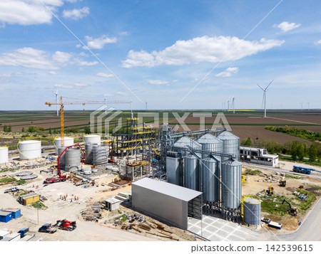 Construction of a modern agricultural grain terminal with wind turbines on the horizon Construction of a modern agricultural grain terminal with wind turbines on the horizon 142539615