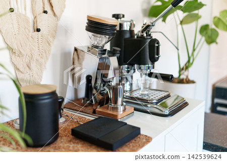 Home barista corner with a manual lever espresso machine and a single dose coffee grinder. Home barista corner with a manual lever espresso machine and a single dose coffee grinder. 142539624