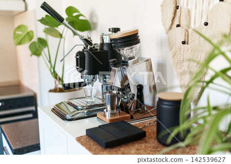 Home barista corner with a manual lever espresso machine and a single dose coffee grinder. Home barista corner with a manual lever espresso machine and a single dose coffee grinder. 142539627