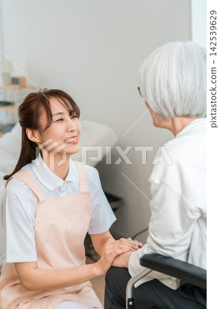 一位女護理員正在照顧一位坐在輪椅上的老婦人。這是一個充滿微笑、溝通順暢的照護環境。 一位女護理員正在照顧一位坐在輪椅上的老婦人。這是一個充滿微笑、溝通順暢的照護環境。 142539629