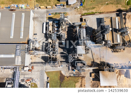 Aerial shot of a manufacturing facility with smoking chimney during production 142539630