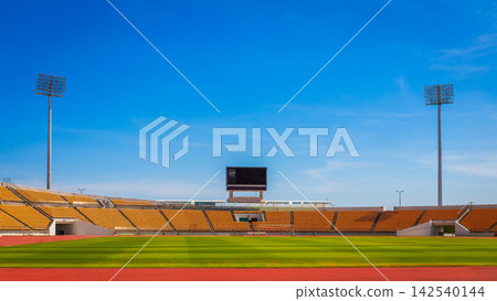 A beautiful stadium with an indoor football field and running track, and a large scoreboard with a clock and spotlights. A beautiful stadium with an indoor football field and running track, and a large scoreboard with a clock and spotlights. 142540144