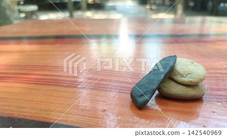 Stacked stone and dark pebble on polished wooden table Stacked stone and dark pebble on polished wooden table 142540969