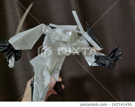 這是一個富有創意的 3D 摺紙模型,描繪了一位身穿白色道服的武術家擺出忍者般的姿勢,反手握劍。 這是一個富有創意的 3D 摺紙模型,描繪了一位身穿白色道服的武術家擺出忍者般的姿勢,反手握劍。 142541456