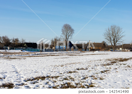 Quiet countryside landscape. Peaceful hamlet with scattered homes and early spring signs Quiet countryside landscape. Peaceful hamlet with scattered homes and early spring signs 142541490