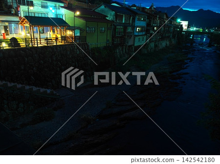 木曾福島宿的秋天:夜晚在木曾川沿岸公園的足浴池,以及依山而建的房屋。 木曾福島宿的秋天:夜晚在木曾川沿岸公園的足浴池,以及依山而建的房屋。 142542180