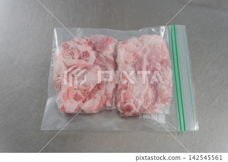 一雙女人的手將大量的豬肉分成小份量。 一雙女人的手將大量的豬肉分成小份量。 142545561