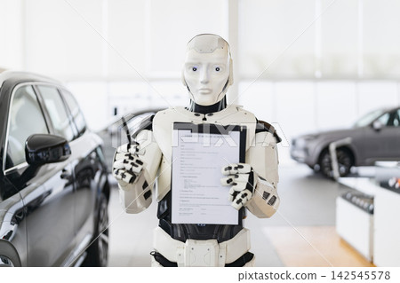A humanoid robot stands in a car dealership holding a vehicle purchase agreement and a pen ready to finalize a sale A humanoid robot stands in a car dealership holding a vehicle purchase agreement and a pen ready to finalize a sale 142545578