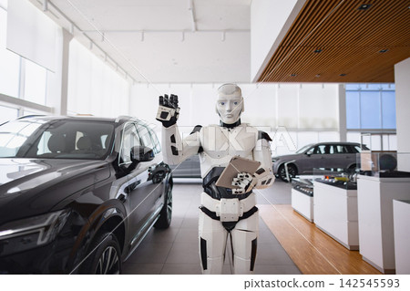 A humanoid robot stands in a modern car dealership, holding a tablet and gesturing with its hand A humanoid robot stands in a modern car dealership, holding a tablet and gesturing with its hand 142545593