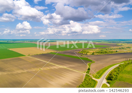 Rural landscape. Aerial view. View of highway and plowed and green fields in spring Rural landscape. Aerial view. View of highway and plowed and green fields in spring 142546293