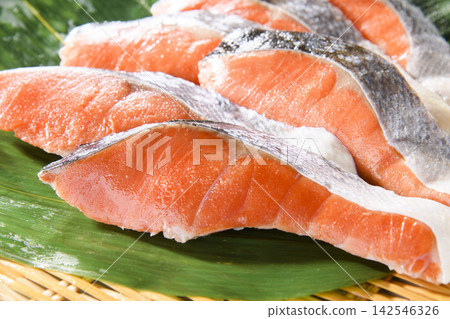 照片上是擺放在竹托盤上的新鮮鮭魚片,這是典型的日本食品。 照片上是擺放在竹托盤上的新鮮鮭魚片,這是典型的日本食品。 142546326