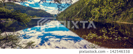 Rocky shore of the mountain lake in an autumn morning. Beautiful nature of Norway. Reflection of the sky in the lake Rocky shore of the mountain lake in an autumn morning. Beautiful nature of Norway. Reflection of the sky in the lake 142546338