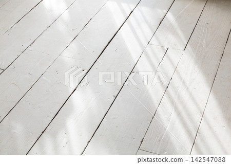 White wooden flooring with sunlight streaming in through the window White wooden flooring with sunlight streaming in through the window 142547088