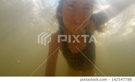 Young girl swimming underwater in thermal water Young girl swimming underwater in thermal water 142547786