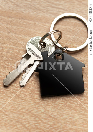 Keys with house shape keychain representing home ownership Keys with house shape keychain representing home ownership 142548326