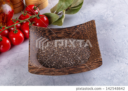 Chia seeds in wooden bowl with cherry tomatoes and bay leaves on stone surface Chia seeds in wooden bowl with cherry tomatoes and bay leaves on stone surface 142548642