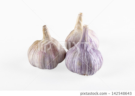 Three purple striped garlic bulbs on white background Three purple striped garlic bulbs on white background 142548643