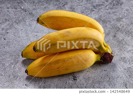 Fresh yellow bananas on gray concrete background Fresh yellow bananas on gray concrete background 142548649