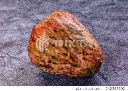 Ripe annona fruit with textured skin on dark surface Ripe annona fruit with textured skin on dark surface 142548692