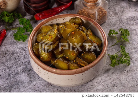 Pickled cucumber slices in ceramic bowl with spices and parsley Pickled cucumber slices in ceramic bowl with spices and parsley 142548795
