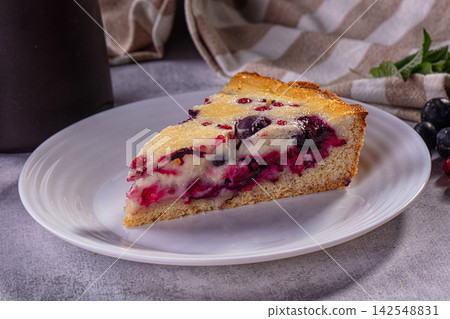 Slice of berry cake with blueberry and red currant on white plate Slice of berry cake with blueberry and red currant on white plate 142548831